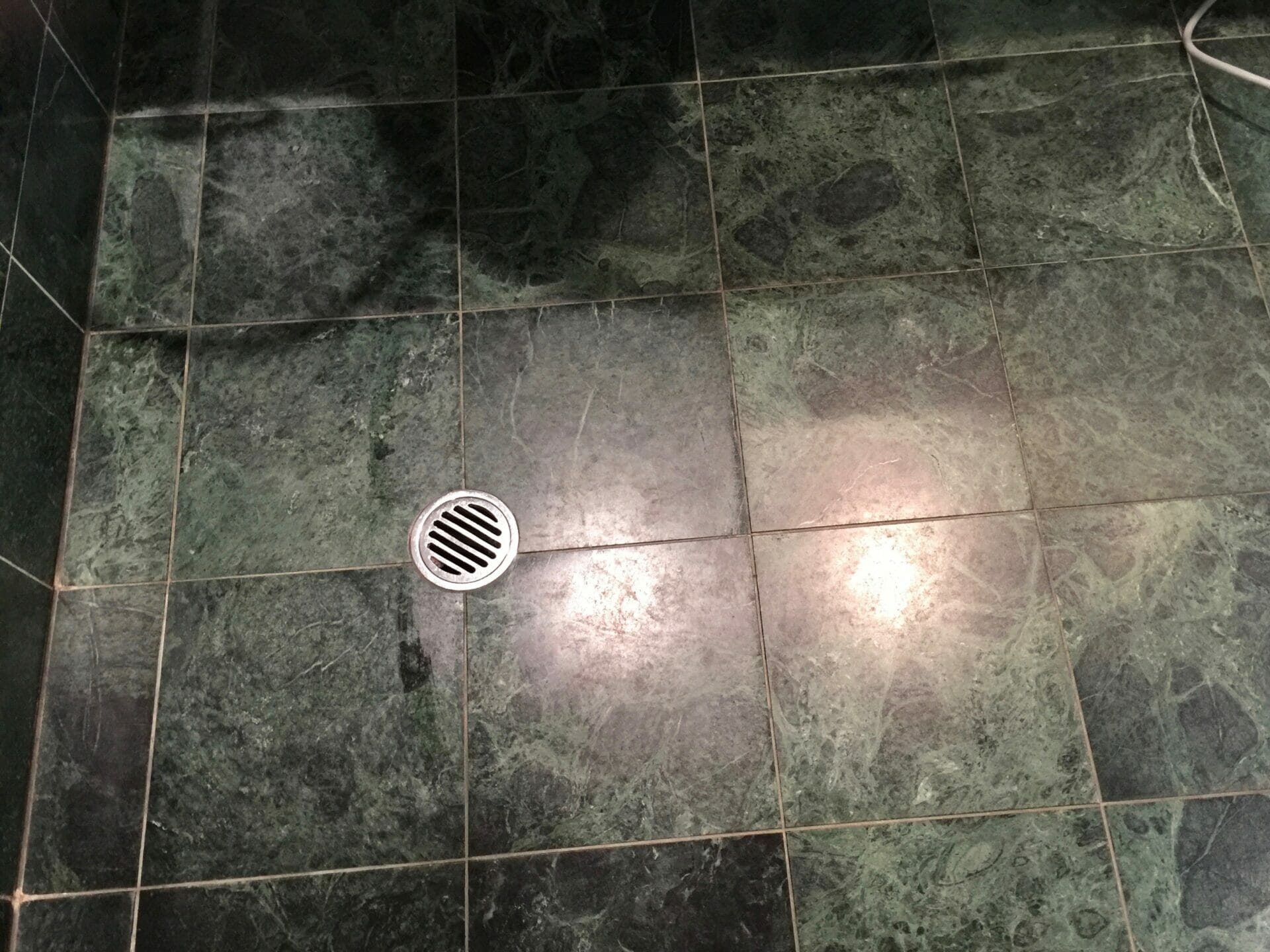 Green marble shower before polishing